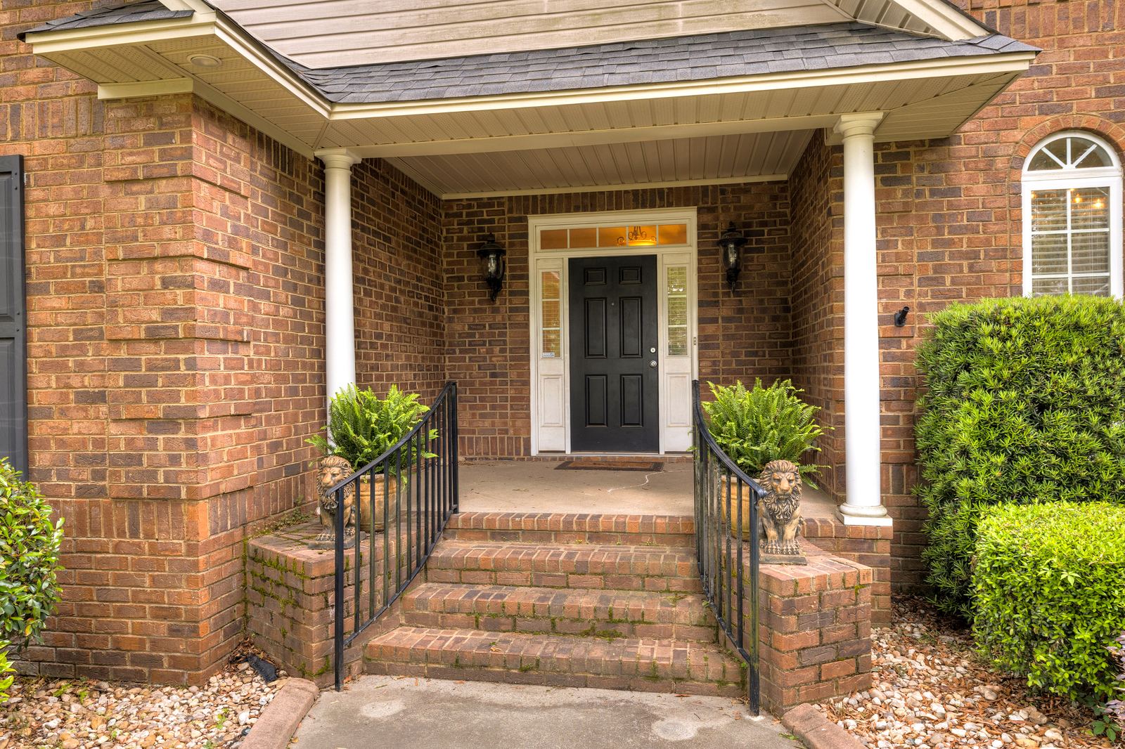 Welcoming brick front porch with iron railings